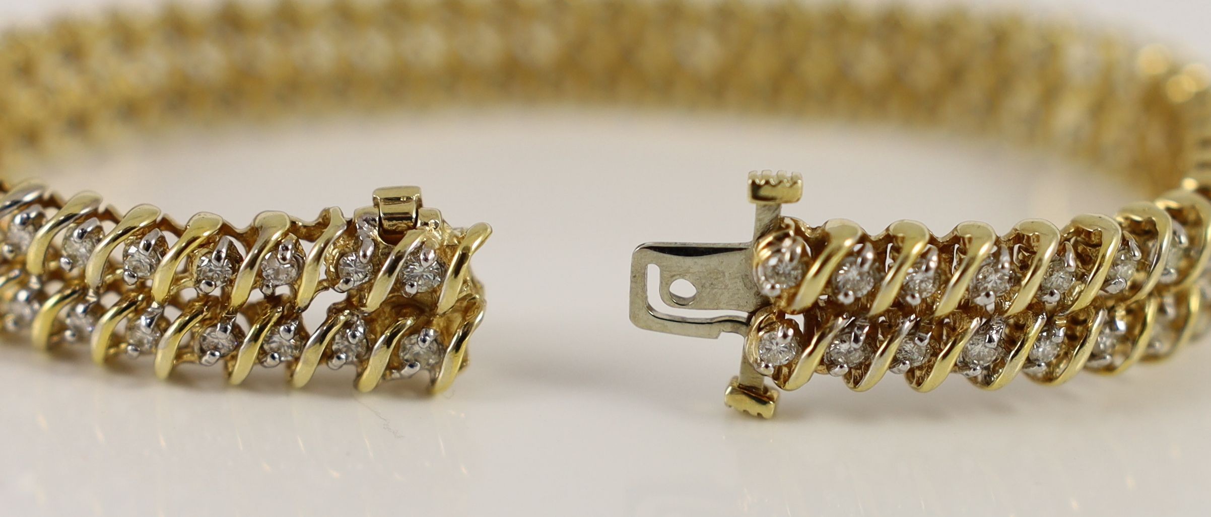 A modern 14k gold and twin row diamond set line bracelet